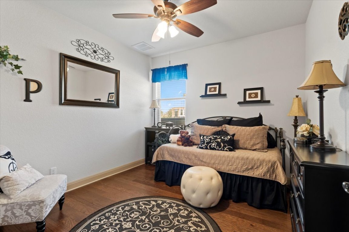 224 Whitney Woods Circle Georgetown, TX 78633 - Photo 26 of 40 a bedroom with a bed and wooden floor