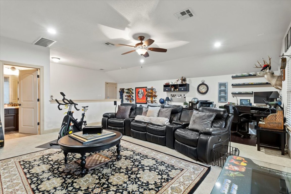 224 Whitney Woods Circle Georgetown, TX 78633 - Photo 31 of 40 a living room with furniture a rug and a chandelier