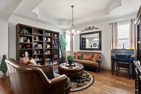 a living room with furniture a bookshelf and a window