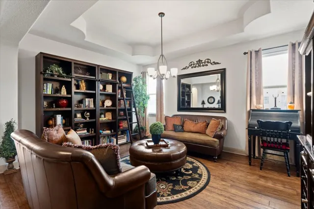 a living room with furniture a bookshelf and a window