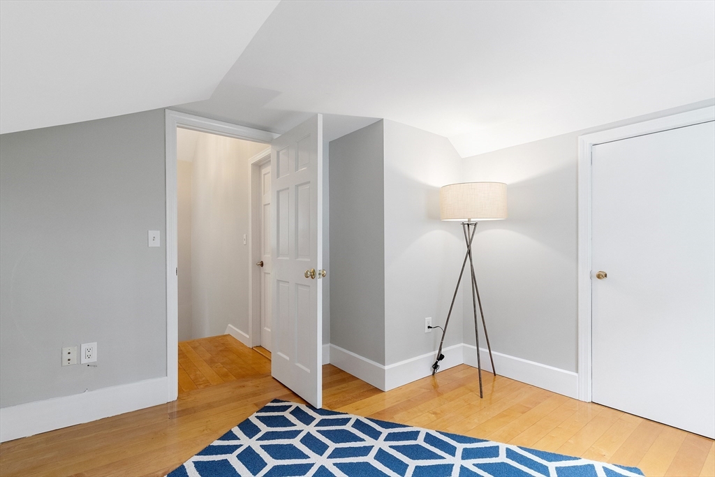 148 Wood Street, Unit 4 Lexington, MA 02421 - Photo 18 of 26 a bedroom with a bed and wooden floor