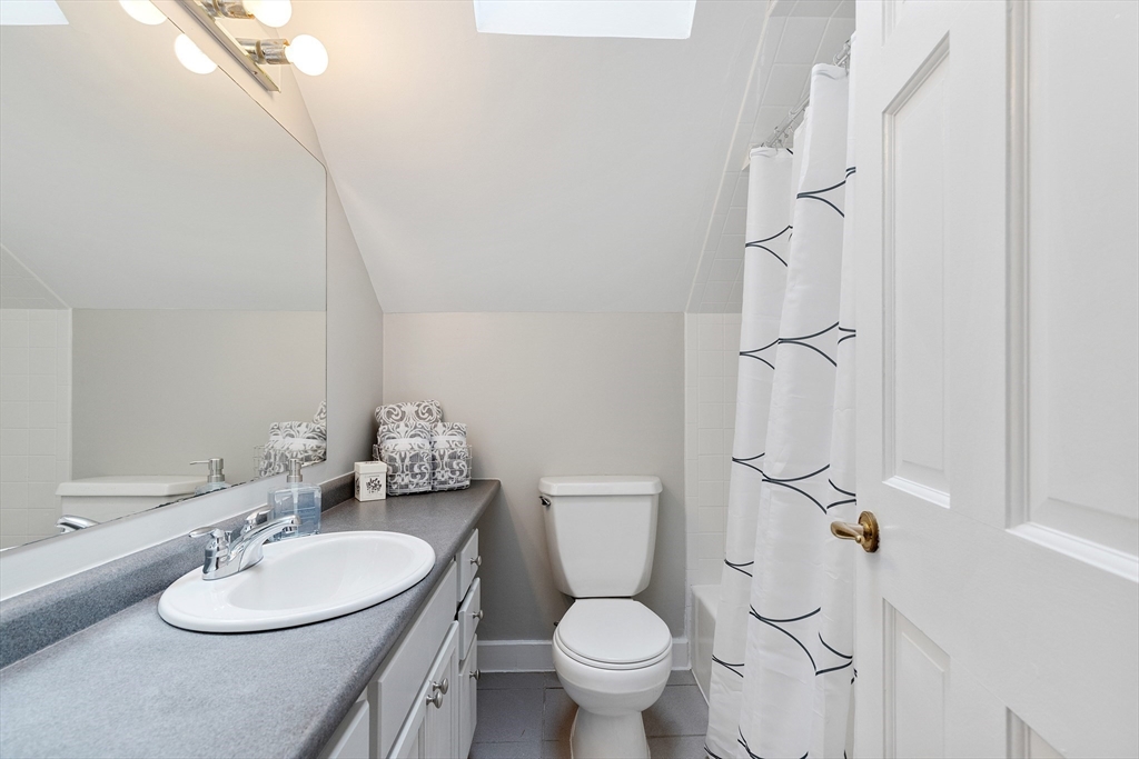 148 Wood Street, Unit 4 Lexington, MA 02421 - Photo 19 of 26 a bathroom with a granite countertop sink toilet a mirror and shower