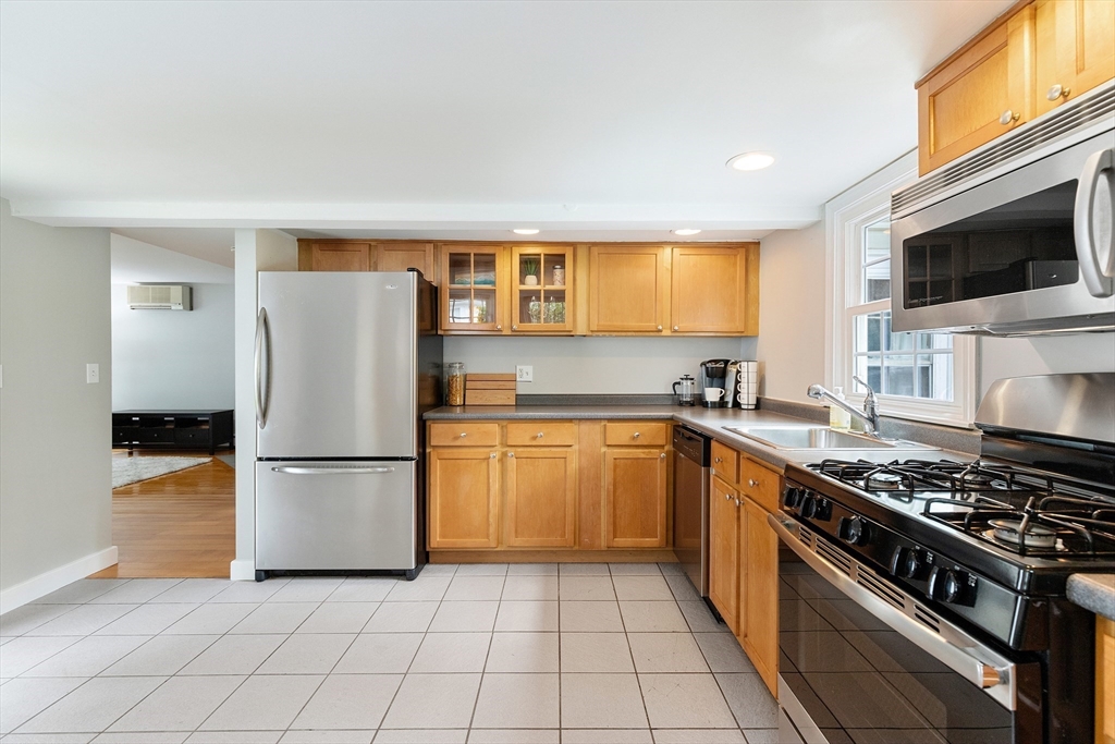 148 Wood Street, Unit 4 Lexington, MA 02421 - Photo 3 of 26 a kitchen with a refrigerator a stove top oven a sink and cabinets