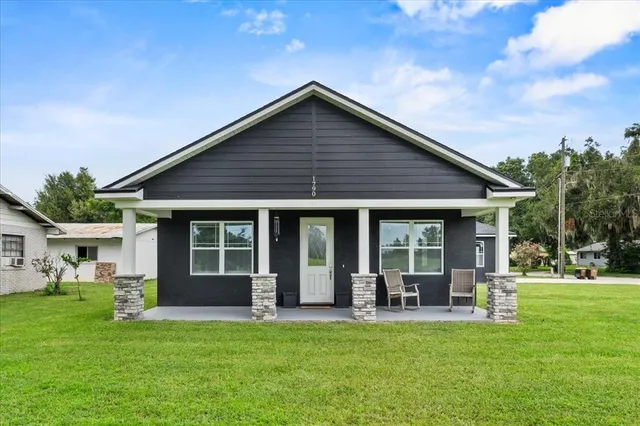 a view of a house with a yard and sitting area