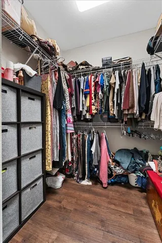 a view of walk in closet with clothes and shoes