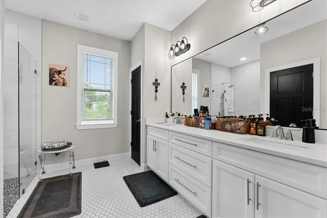 a bathroom with a double vanity sink a mirror and a bathtub