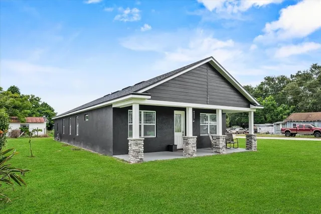 a front view of house with a garden and trees