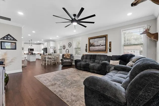 a living room with furniture wooden floor and a large window