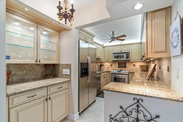 a kitchen with granite countertop a sink stainless steel appliances and counter space
