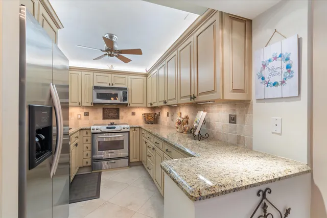 a kitchen with stainless steel appliances granite countertop a refrigerator oven a sink dishwasher and white cabinets with wooden floor