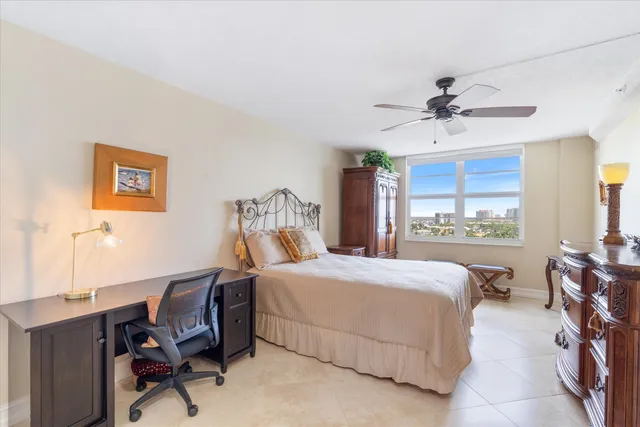 a bedroom with a bed a desk and chair with window