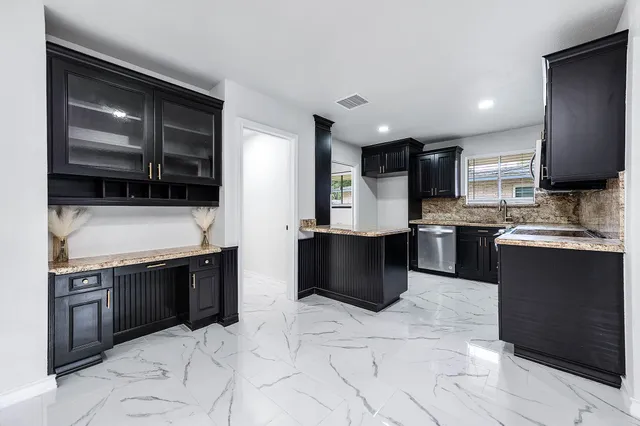 a kitchen with stainless steel appliances granite countertop a stove sink and cabinets