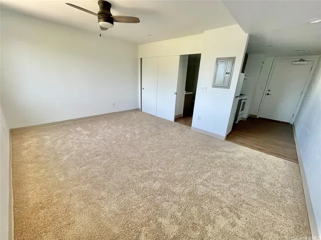 an empty room with a ceiling fan and a window