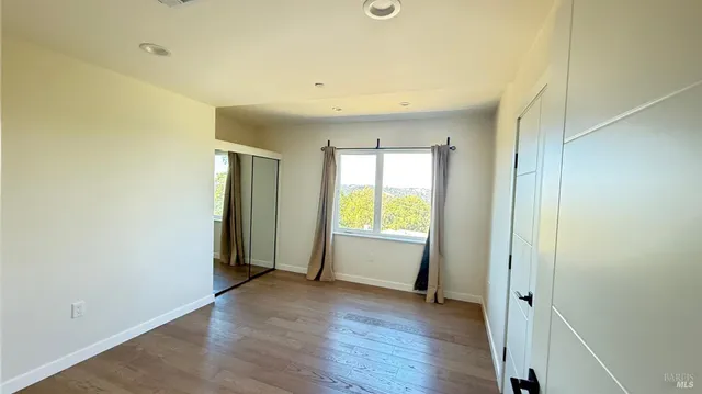 an empty room with wooden floor and a window