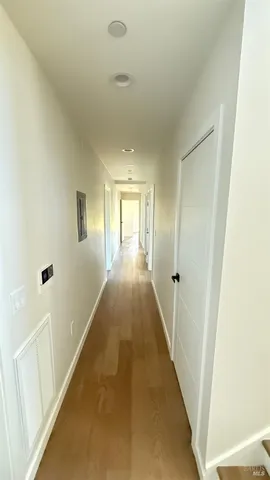 a view of a hallway with wooden floor and staircase