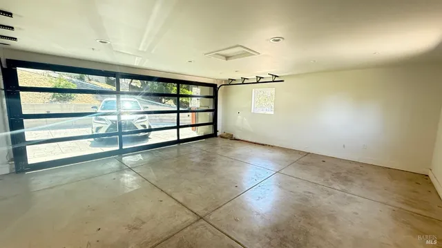 an empty room with windows and door