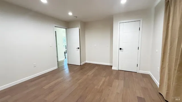 a view of an empty room with wooden floor