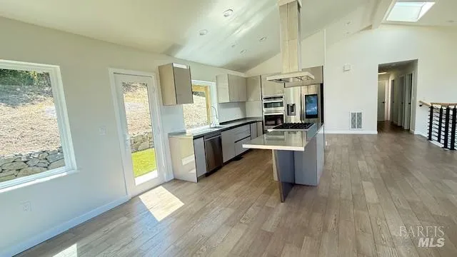 a kitchen with stainless steel appliances wooden floors and wooden cabinets
