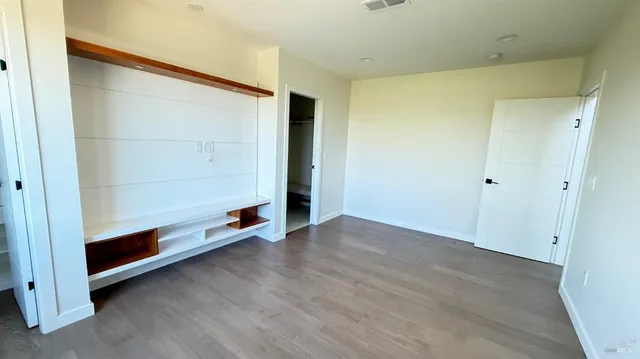 a room with wooden floor and white walls