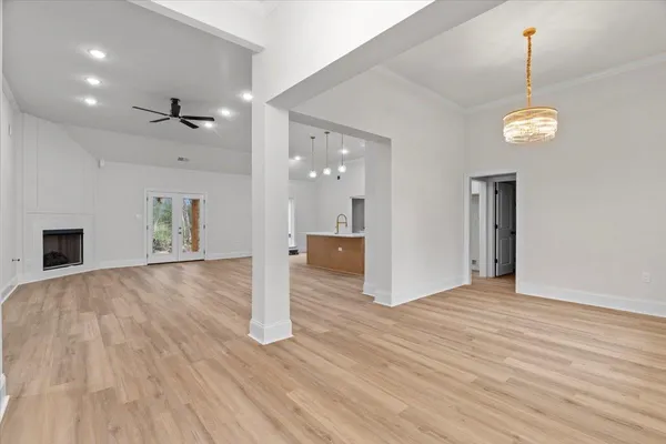 a view of empty room with wooden floor and ceiling fan