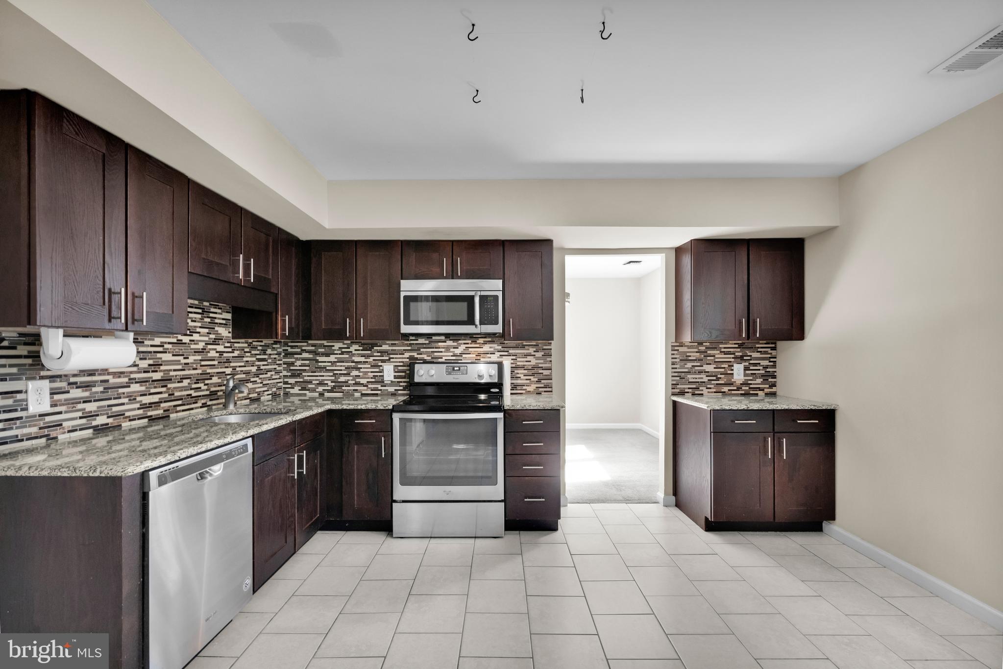 2773 Anvil Place Doylestown, PA 18902 - Photo 9 of 36 a kitchen with stainless steel appliances granite countertop a stove top oven sink and cabinets