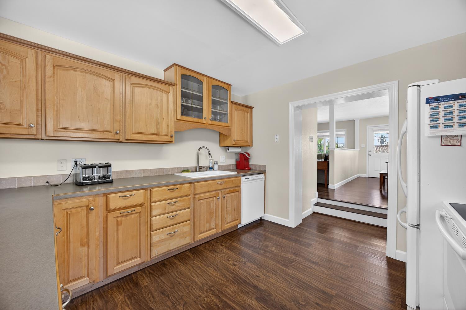 145 Oak Ridge Drive Ione, CA 95640 - Photo 30 of 61 a kitchen with granite countertop a sink cabinets and wooden floor