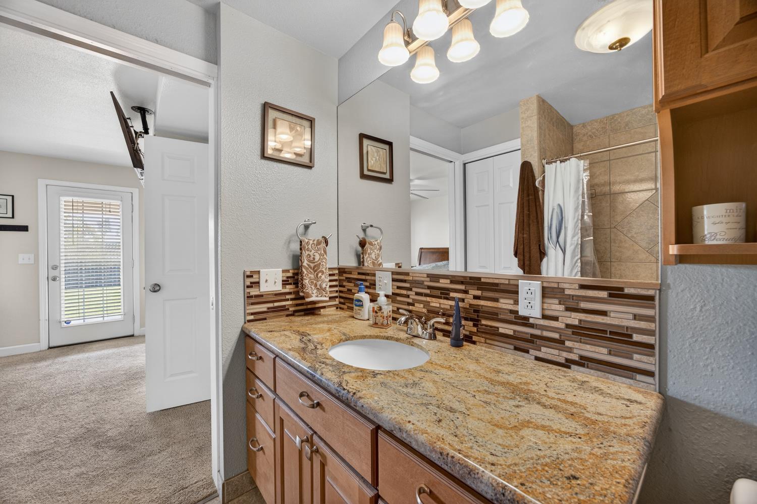 145 Oak Ridge Drive Ione, CA 95640 - Photo 52 of 61 a bathroom with a granite countertop sink and a mirror