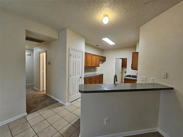 a kitchen with stainless steel appliances granite countertop a sink and a refrigerator