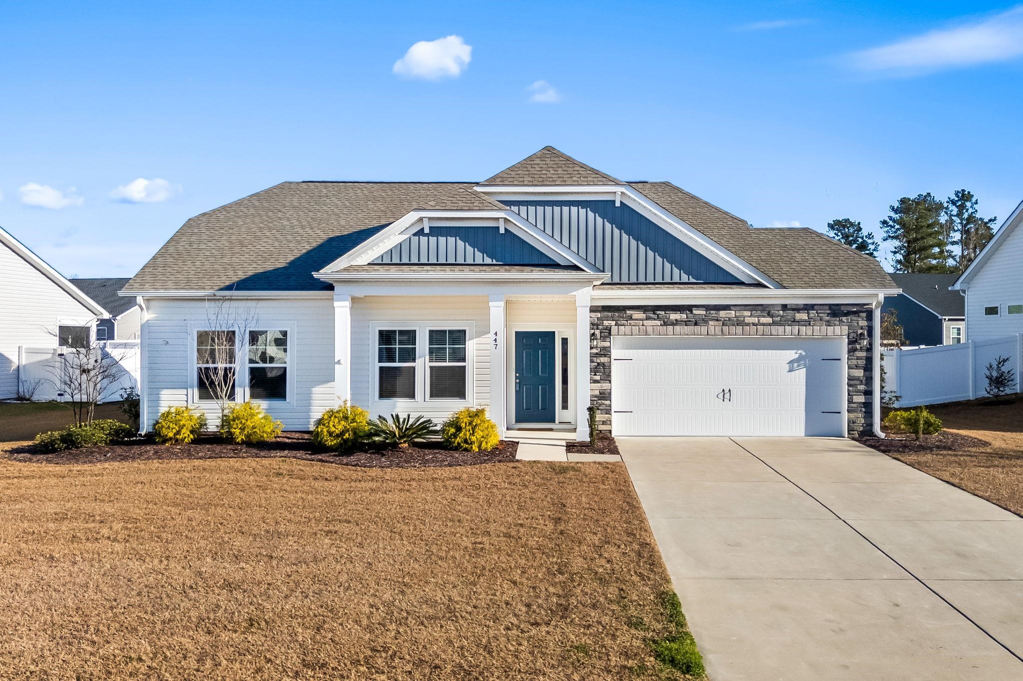 447 Honeyhill Loop Conway, SC 29526 - Photo 1 of 39 View of front facade with a shingled roof, board and batten siding, driveway, an attached garage, and stone siding