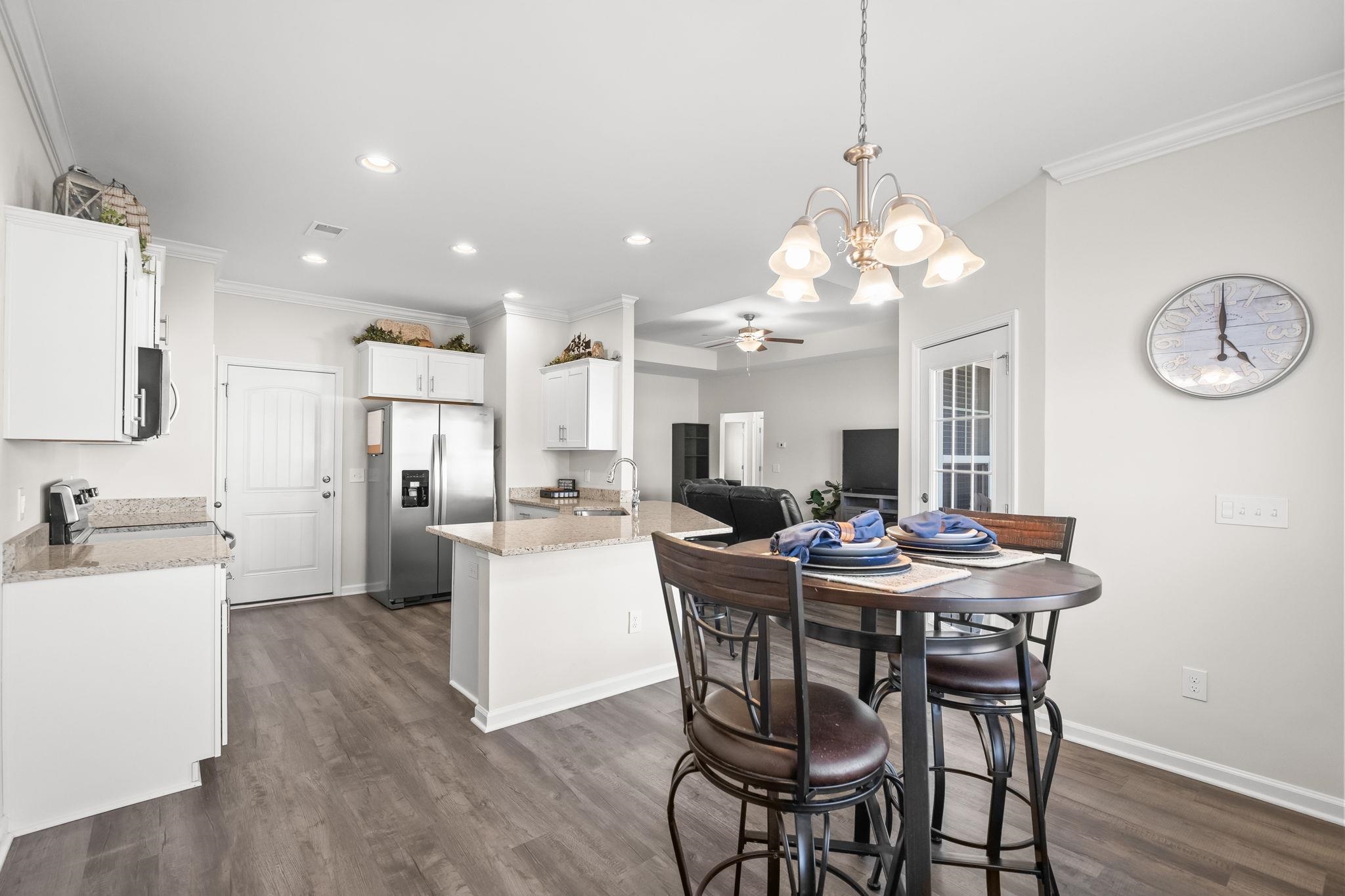 447 Honeyhill Loop Conway, SC 29526 - Photo 11 of 39 Dining space featuring crown molding, dark wood-type flooring, a ceiling fan, a chandelier, and recessed lighting