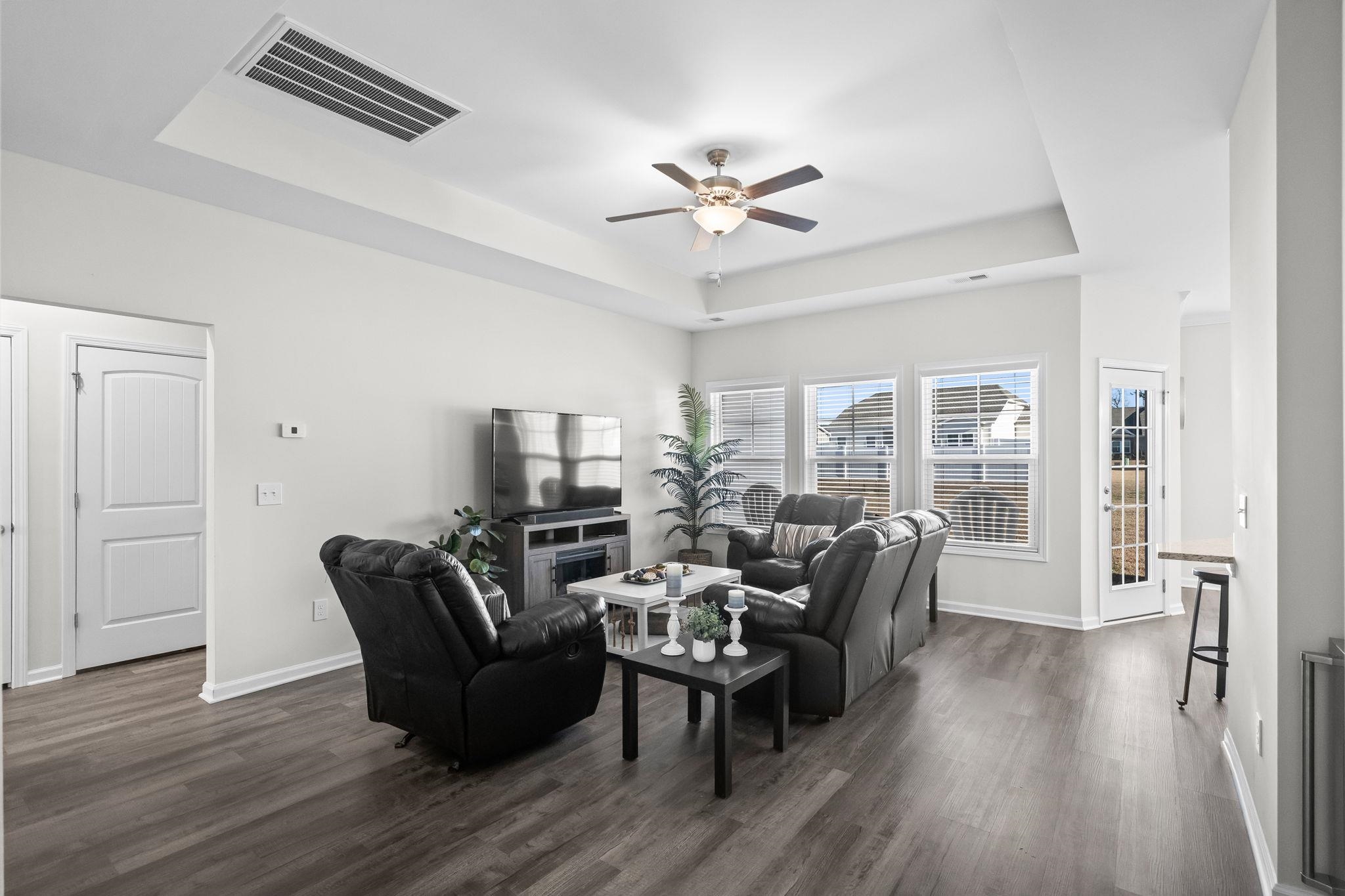 447 Honeyhill Loop Conway, SC 29526 - Photo 5 of 39 Living room featuring a tray ceiling, dark wood-style floors, and a ceiling fan