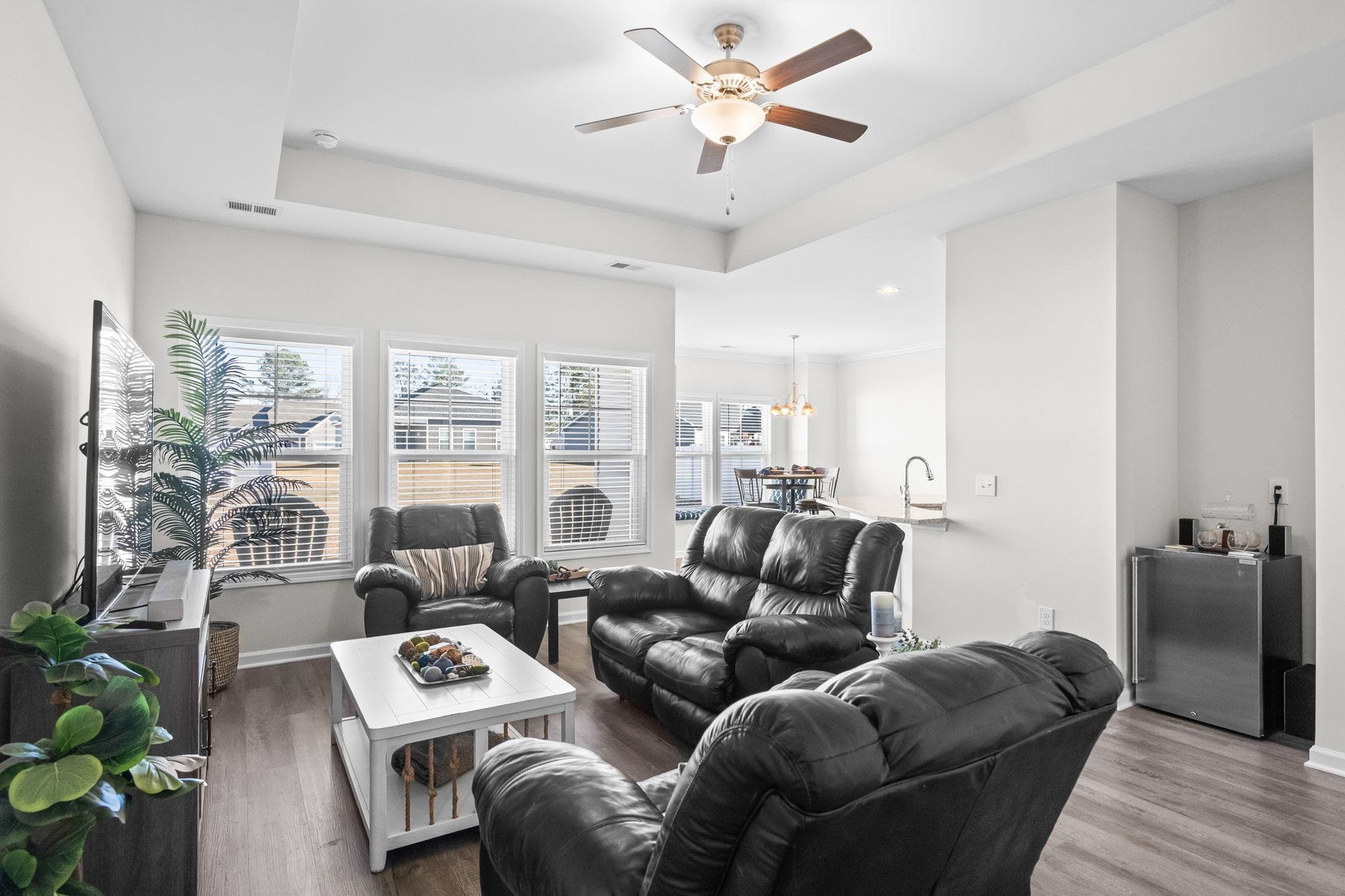 447 Honeyhill Loop Conway, SC 29526 - Photo 6 of 39 Living room featuring a raised ceiling, wood finished floors, ceiling fan, and a chandelier