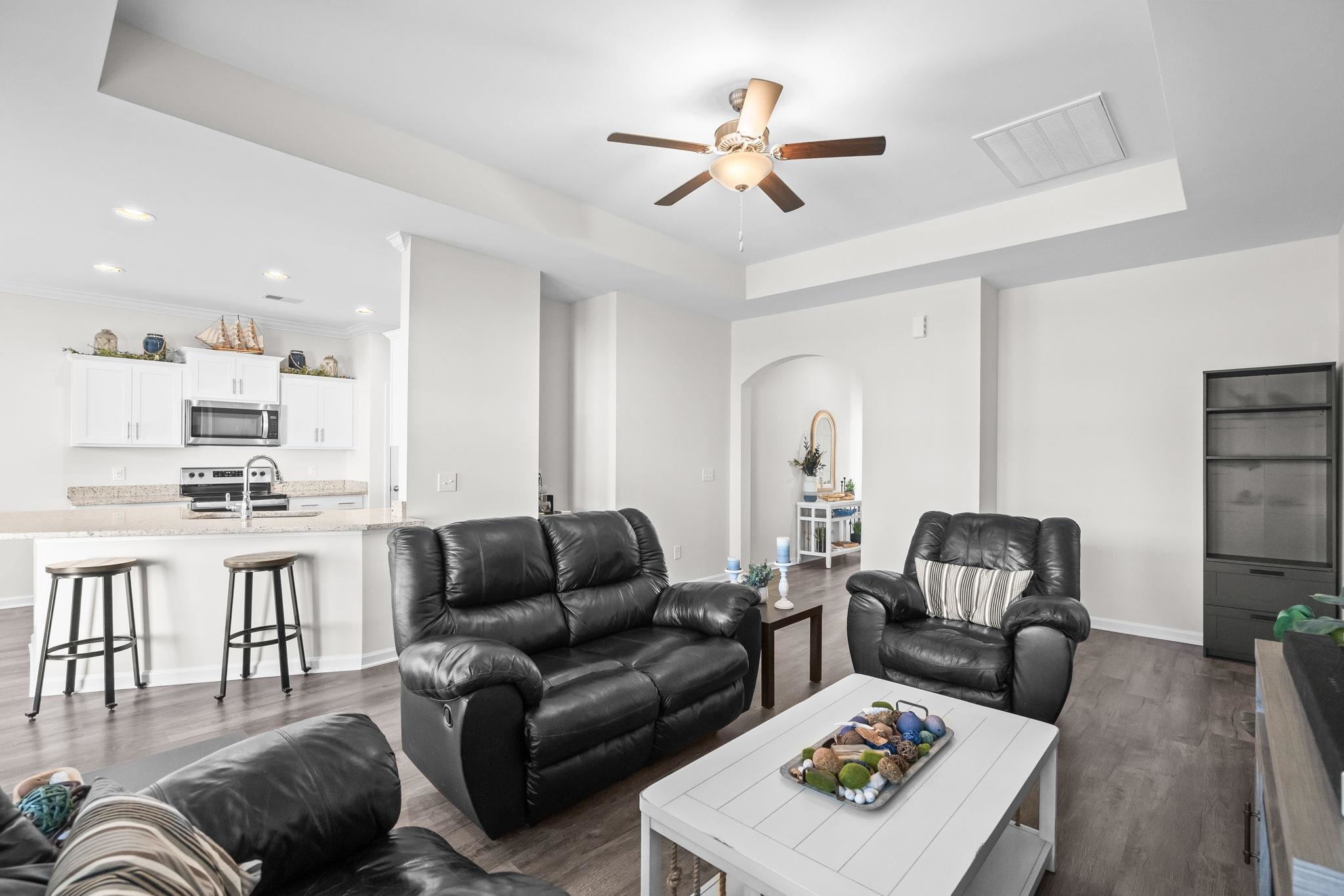 447 Honeyhill Loop Conway, SC 29526 - Photo 8 of 39 Living area with dark wood finished floors, a tray ceiling, arched walkways, and a ceiling fan