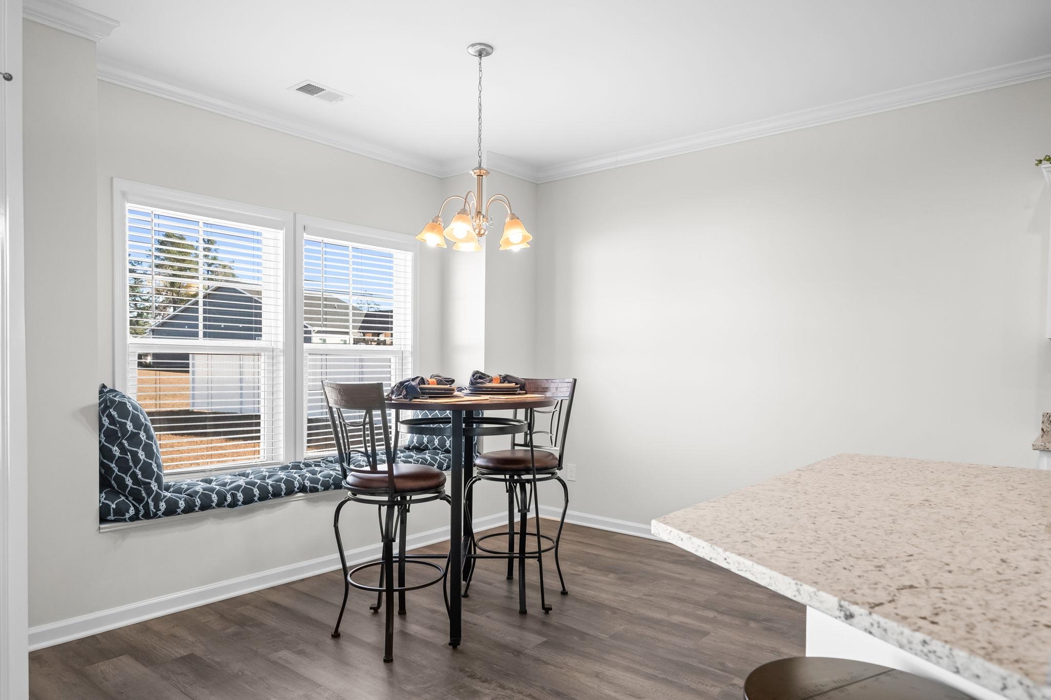 447 Honeyhill Loop Conway, SC 29526 - Photo 9 of 39 Dining area featuring crown molding, dark wood-style flooring, and a chandelier