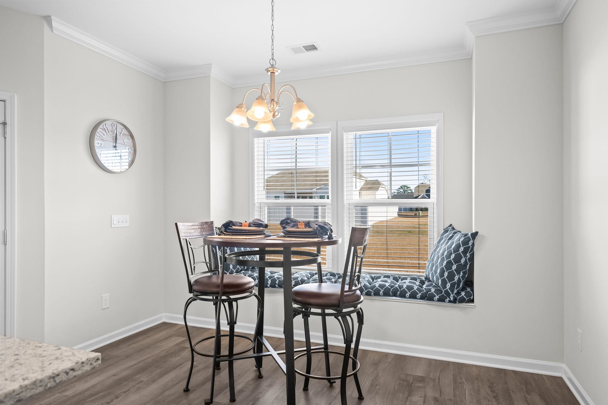 447 Honeyhill Loop Conway, SC 29526 - Photo 10 of 39 Dining area featuring dark wood-type flooring, crown molding, and a chandelier