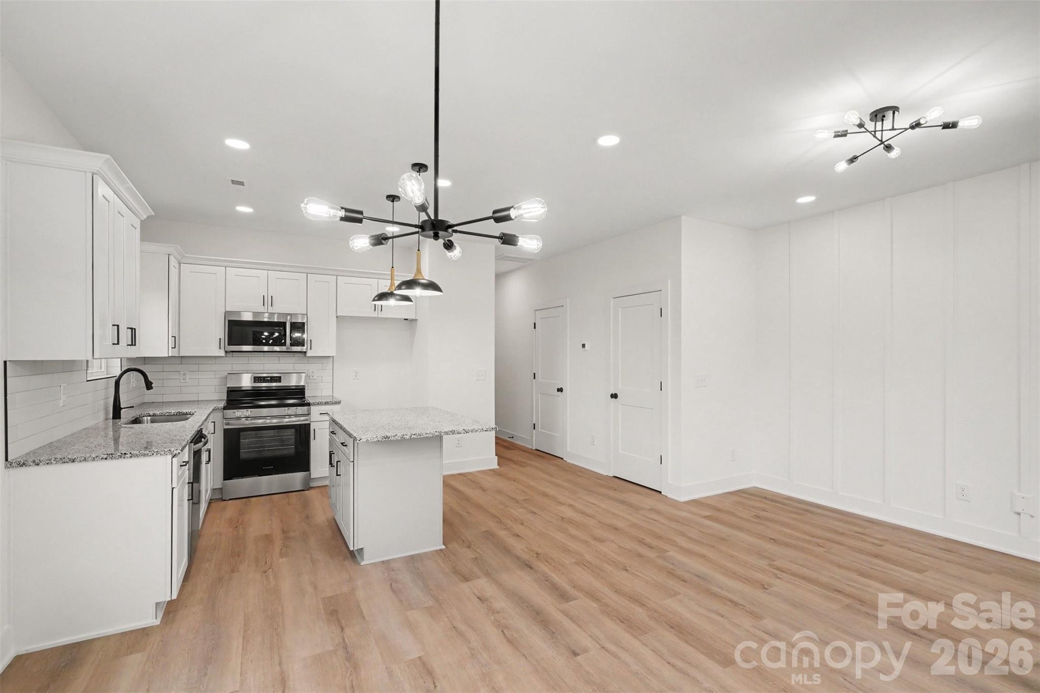 7521 Lawyers Road Charlotte, NC 28227 - Photo 14 of 35 a kitchen with kitchen island a stove a sink and a refrigerator