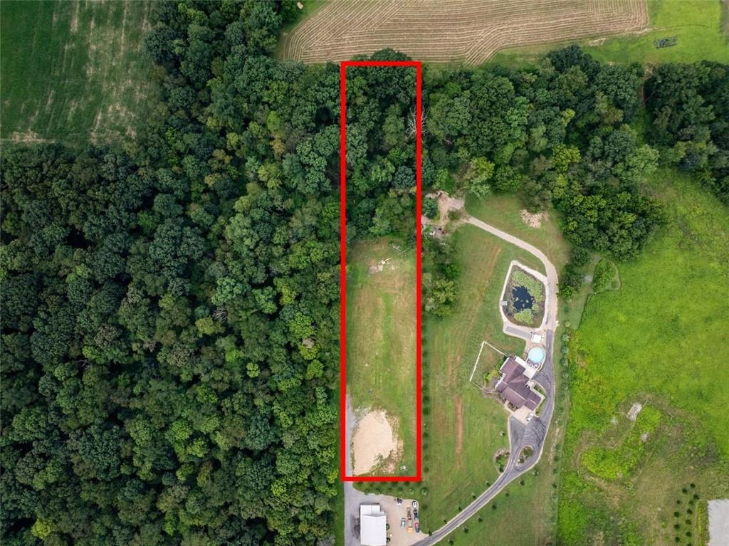 an aerial view of a house with a yard and trees