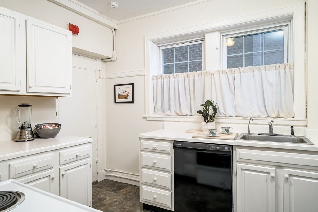 986 Memorial Drive, Unit 404 Cambridge, MA 02138 - Photo 15 of 41 a kitchen with cabinets appliances a sink and a window