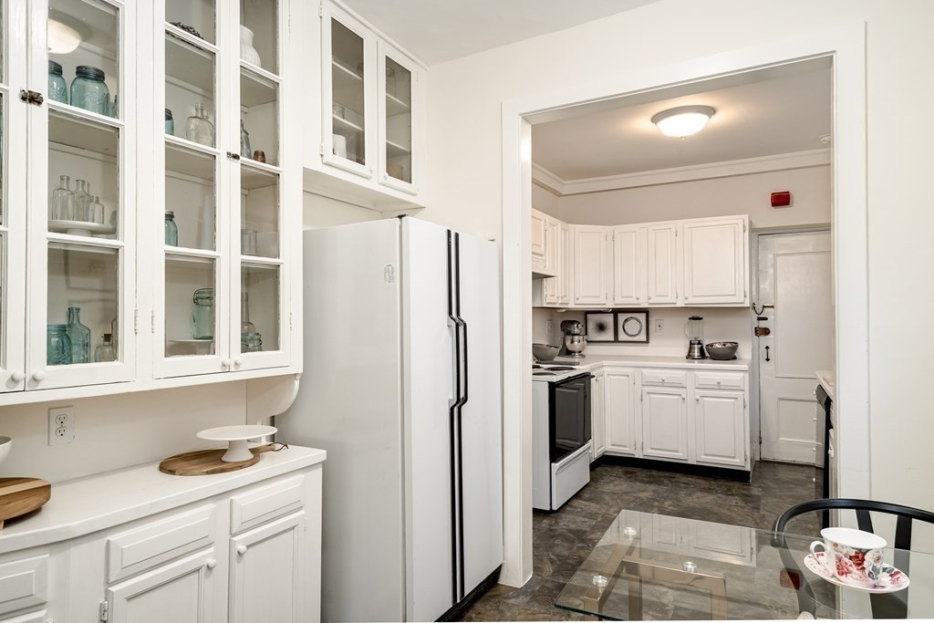 986 Memorial Drive, Unit 404 Cambridge, MA 02138 - Photo 20 of 41 a kitchen with a refrigerator sink and white cabinets