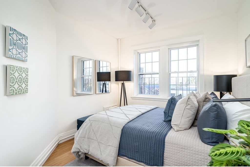 986 Memorial Drive, Unit 404 Cambridge, MA 02138 - Photo 30 of 41 a bedroom with a bed and glass windows