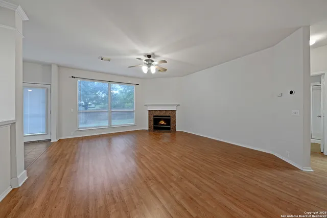a view of a livingroom with wooden floor and a kitchen