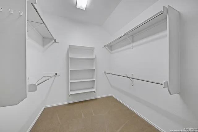 an empty room with a chandelier fan