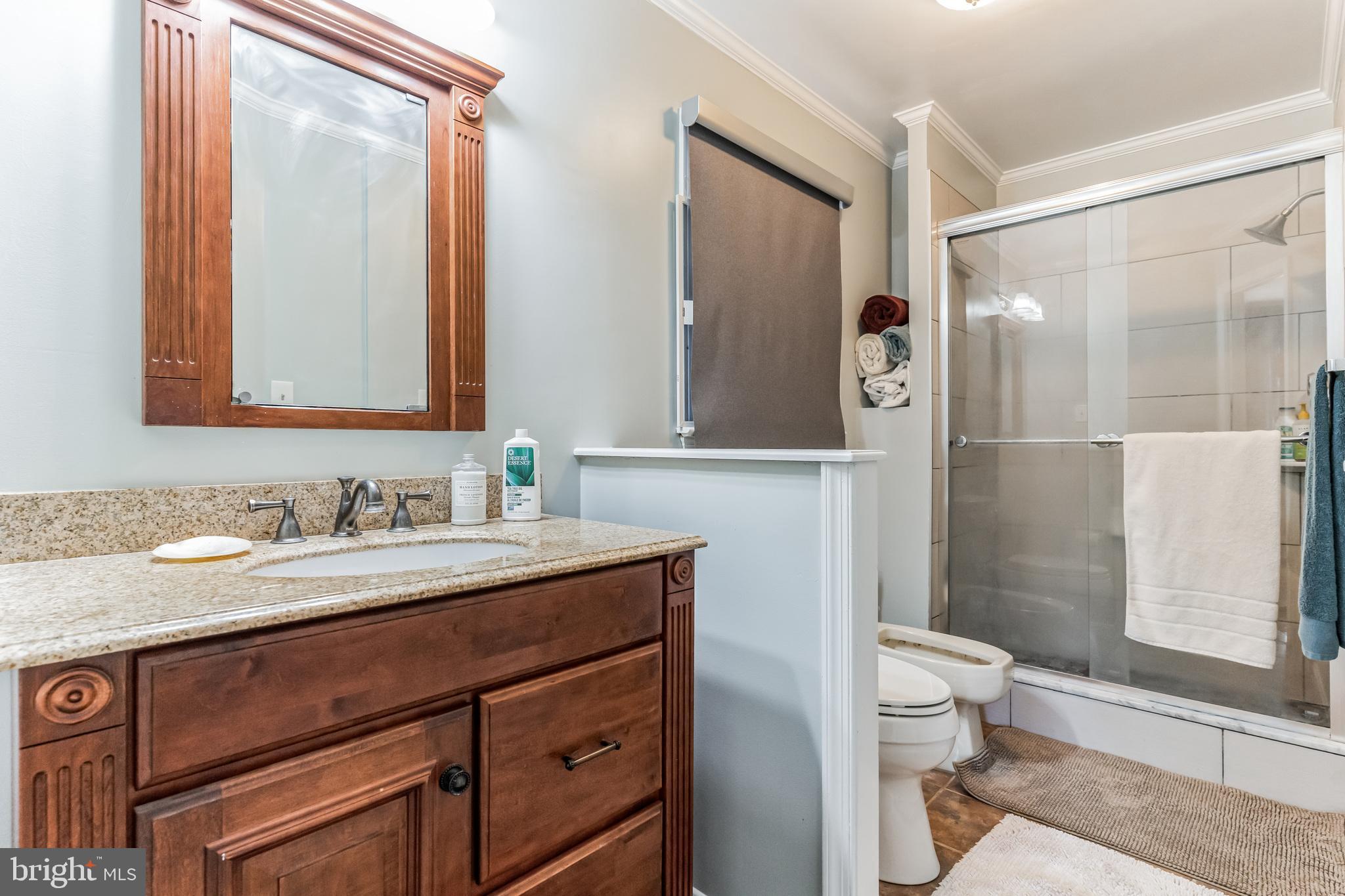 9329 Harvey Road Silver Spring, MD 20910 - Photo 20 of 40 a bathroom with a granite countertop sink toilet mirror and a shower