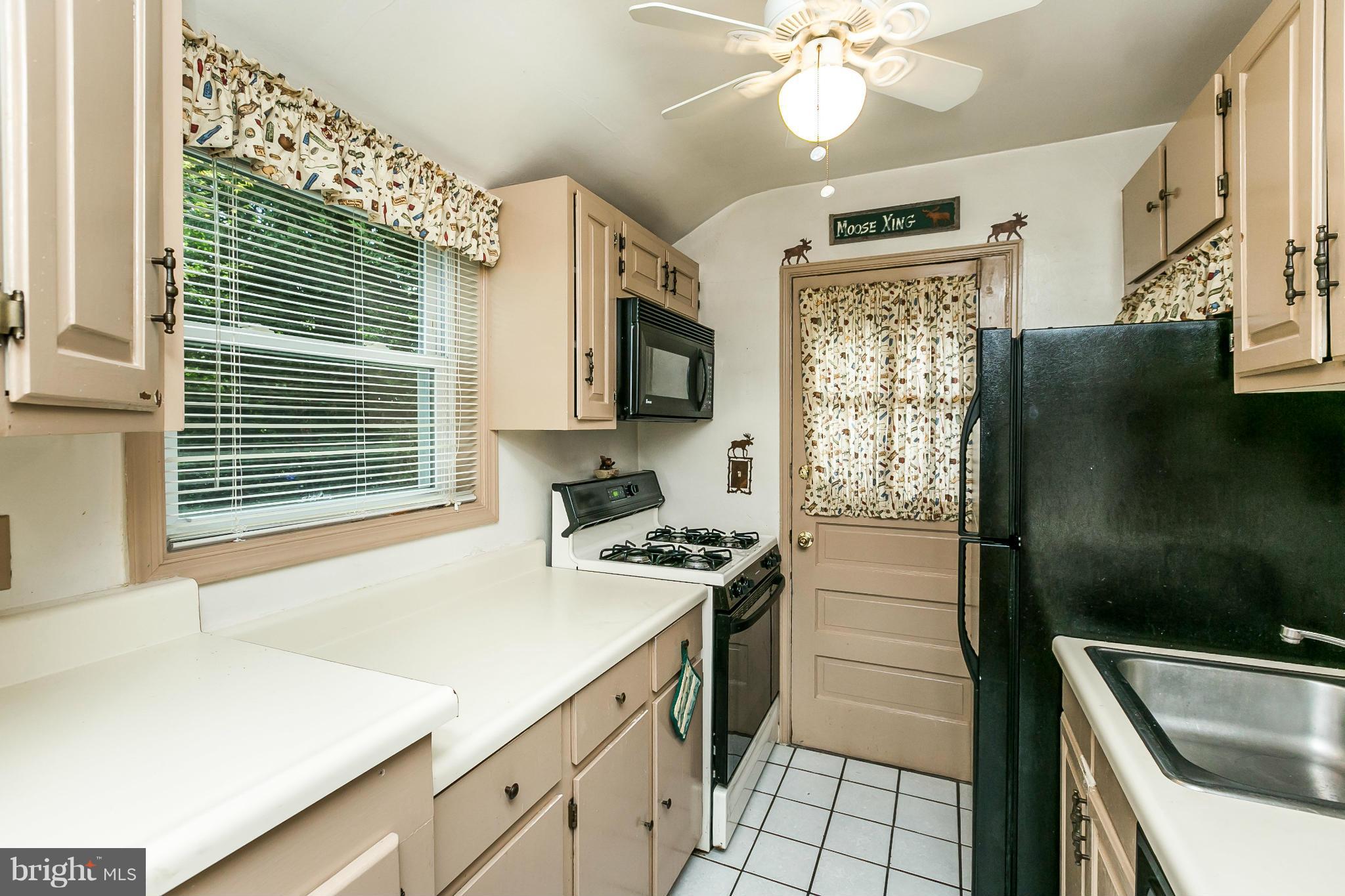 2907 Weisman Road Silver Spring, MD 20902 - Photo 9 of 30 a kitchen with a sink a stove cabinets and a window