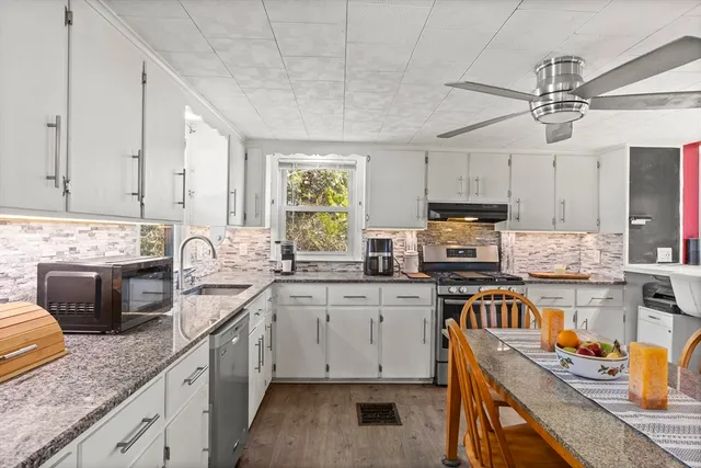 a kitchen with granite countertop stainless steel appliances a sink and cabinets