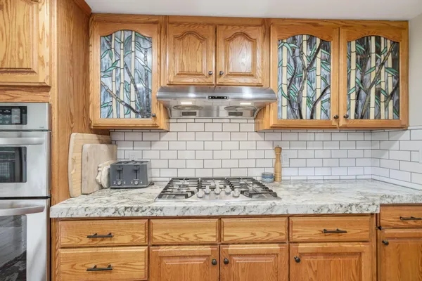 a kitchen with granite countertop a stove a sink and cabinets