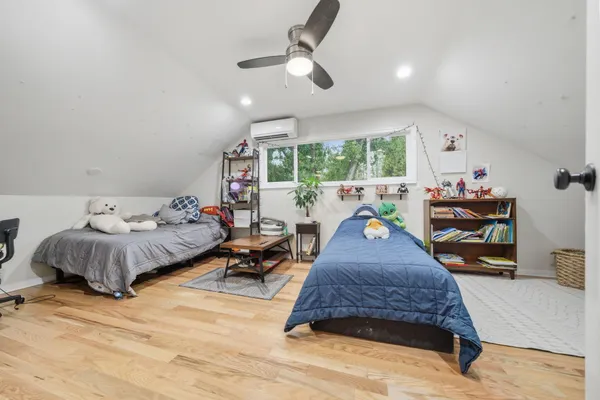 a living room with a bed furniture chandelier and a large window