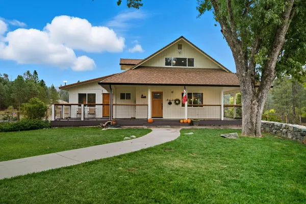 a view of a house with a yard and porch