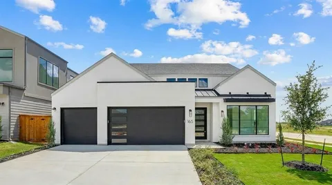 a front view of a house with a garden and outdoor seating