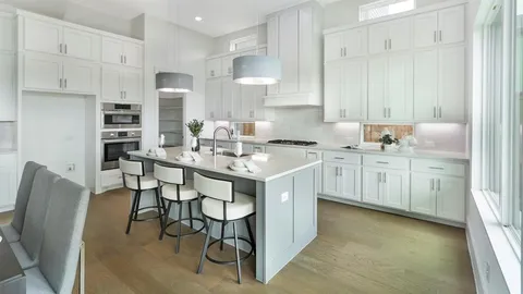 a kitchen with stainless steel appliances kitchen island granite countertop a table chairs sink and cabinets
